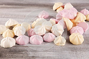 Meringue. Crispy white and pink twisted meringue. Concept love of sweet on table