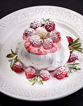 Meringue pavlova cake with whipped cream and fresh raspberries