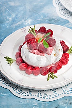 Meringue pavlova cake with whipped cream and fresh raspberries