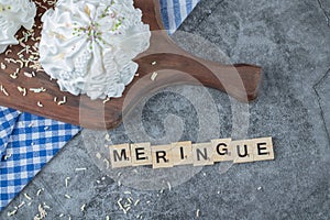 Meringue writing with wooden dices around the cookies