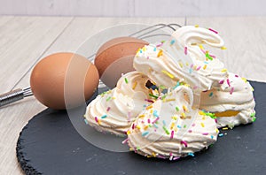 Meringues with the ingredients to create them including eggs and sugar