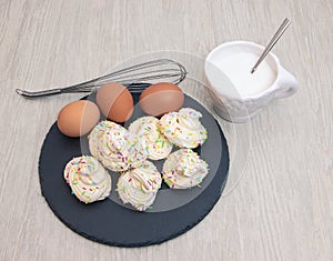 Meringues with the ingredients to create them including eggs and sugar