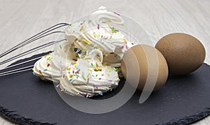 Meringues with the ingredients to create them including eggs and sugar photo