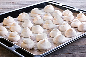 Meringues. Small white meringue sweets on tray photo