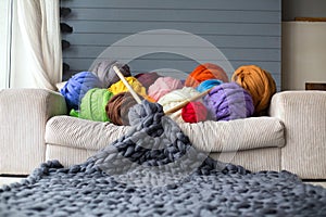 Merino wool balls in multicolour lying on white sofa with merino