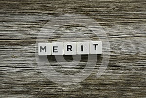 Merit word made of square letter word on wooden background