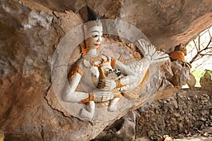Mermaid feeds her son in the cave in Vang Vieng city, Laos.