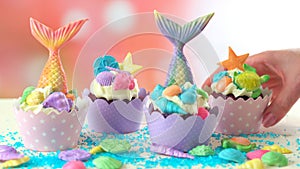 Mermaid theme cupcakes with colorful glitter tails, shells and sea creatures.