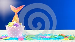 Mermaid theme cupcakes with colorful glitter tails, shells and sea creatures.