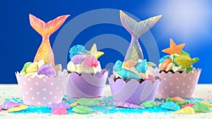 Mermaid theme cupcakes with colorful glitter tails, shells and sea creatures.