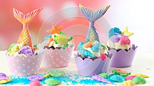 Mermaid theme cupcakes with colorful glitter tails, shells and sea creatures.