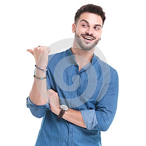 Merry casual man laughing and pointing to the side