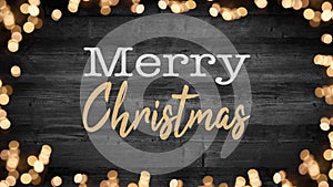 Merry Christmas background holiday greeting card - Frame of bokeh lights and flares, isolated on rustic dark black wooden table