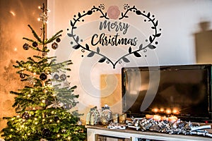 Merry Christmas beautiful living room tree setup aith gifts decorated at home textspace saying merry christmas