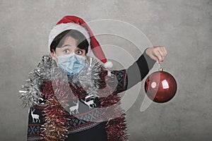 Merry Christmas, boy with medical mask hold a christmas ball