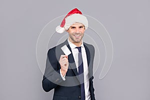 merry christmas. businessman in santa claus hat show credit or debit card.