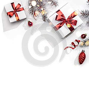 Merry Christmas card made of fir branches, gift boxes, red decoration, sparkles and confetti on white background. Xmas