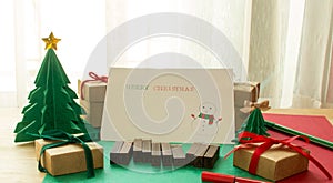 Merry christmas card,paper christmas tree with presents, pines a