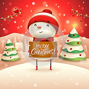 Merry Christmas! Cheerful snowman holds wooden board sign in Christmas snow scene winter landscape.