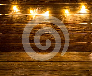 Merry Christmas! Christmas light background on brown rustic wooden background