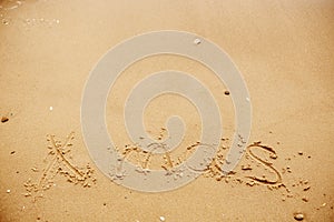 Merry Christmas concept,happy holidays. Xmas text on sandy beach