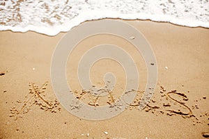 Merry Christmas concept,happy holidays. Xmas text on sandy beach