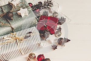 merry christmas concept. presents with ornaments pine cones anise and lights on rustic white wooden background top view, space