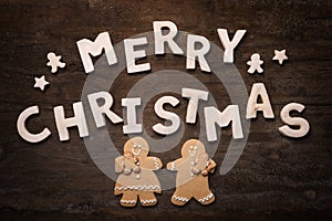 Merry Christmas With Cookie Letters on Wooden Background WithGingerbread People