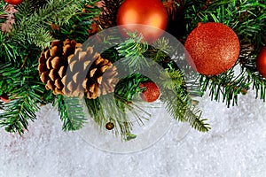 Merry Christmas decorative ball on snow with branch pine cone