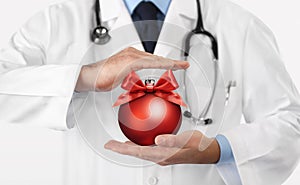 Merry Christmas from doctor,, best wishes concept, hands with xmas red ball, gift card banner web