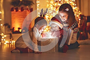 Merry Christmas! family mother and children with magic gift at