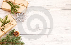 Merry Christmas frame and wallpaper. Happy New Year composition. Christmas gift, pine cones, fir branches on wooden white