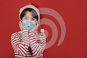 Merry Christmas,funny kid with medical mask wearing Santa Claus hat
