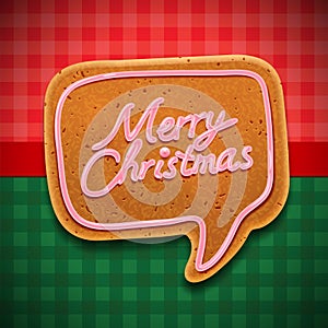 Merry Christmas gingerbread cookies in speech bubble shape. Xmas theme on red and green checkered tablecloth background