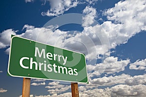 Merry Christmas Green Road Sign Over Clouds and Sky