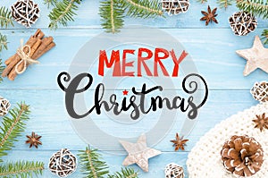 Merry Christmas greeting card with handwriting on rustic blue wooden background with christmas tree, cinnamone,anice photo