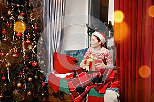 Merry Christmas. Happy child with magic gift at home near Christmas tree.