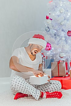 Merry Christmas and Happy Holiday Young man with magic gift box on Christmas