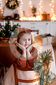 Merry Christmas and Happy Holidays. Cheerful cute child girl having fun in Christmas interior.