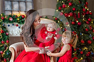 Merry Christmas and Happy Holidays Cheerful mom and her cute daughter girl exchanging gifts. Parent and little child having fun