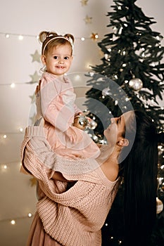 Merry Christmas and Happy Holidays. Cheerful mom and her cute daughter-girl hug and have fun
