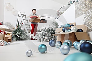 Merry Christmas and Happy Holidays! Child decorate the Christmas tree indoors