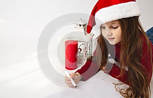 Merry Christmas and Happy Holidays! Cute little girl writing a letter to Santa Claus on a white background