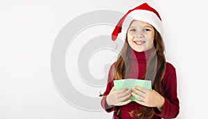 Merry Christmas and Happy Holidays! Cute little girl writing a letter to Santa Claus on a white background