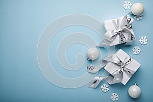 Merry Christmas and Happy Holidays greeting card, frame, banner. New Year. Christmas white, silver ornaments and gifts on blue