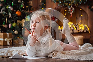 Little child girl writes letter Santa Claus and dreams of a gift background