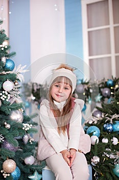 Merry Christmas, happy holidays! New Year 2020. little cute girl sitting on a New Year`s outdoor decorated terrace. A child decora