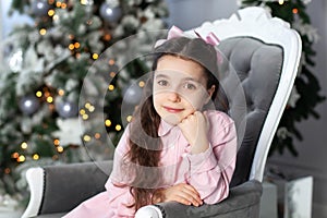 Merry Christmas, happy holidays! New Year. Portrait of little girl dreaming at Christmas near Christmas tree. Holidays and childho
