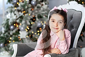 Merry Christmas, happy holidays! New Year. Portrait of little girl dreaming at Christmas near Christmas tree. Holidays and childho