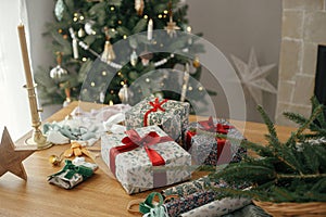 Merry Christmas and Happy Holidays! Stylish christmas gifts and festive decorations on table on background of beautiful vintage